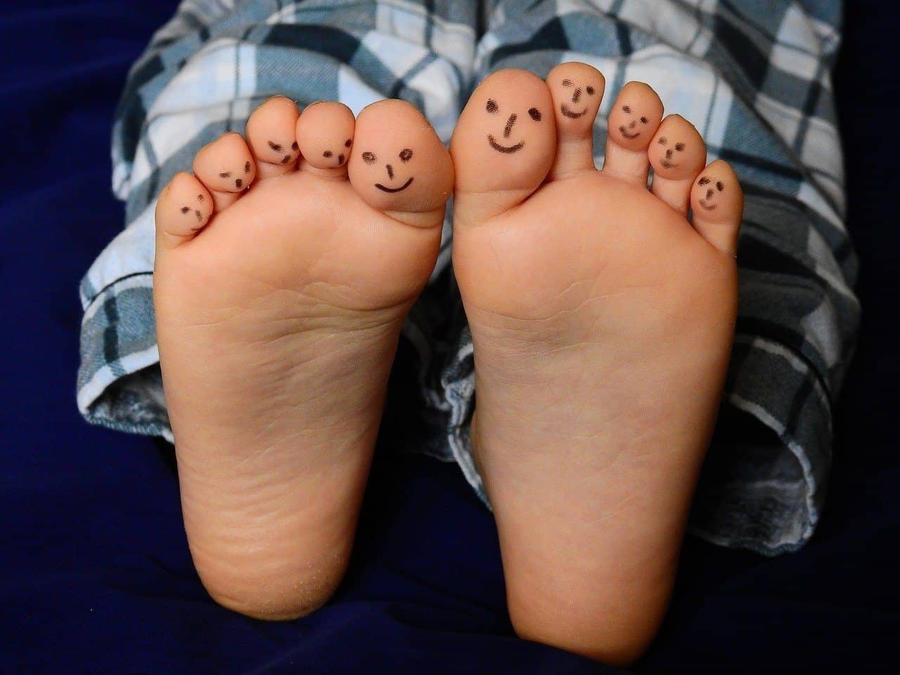 feet with smiley faces drawn on the toes