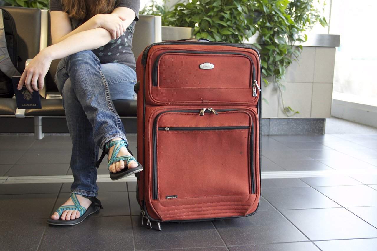 woman at the airport with roller carryon bag ready to travel